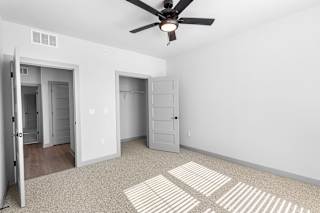 A room with a ceiling fan and two doors at Arbour Place Apartments, Jeffersonville, IN, 47130