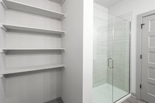A white shelving unit with a glass door at Arbour Place Apartments, Jeffersonville