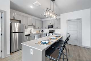 A modern kitchen with a dining table set for two.