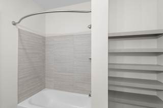 A white bathtub with a shower curtain in a bathroom.at Arlington Farms, Greenwood, Indiana, 46143