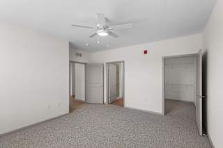 A room with a ceiling fan and carpeted floor.at Arlington Farms, Greenwood, IN, 46143