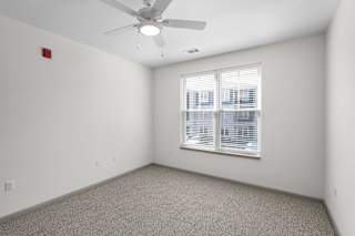 A room with a ceiling fan and a window with blinds.at Arlington Farms, Greenwood, Indiana