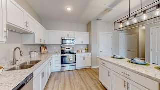 A modern kitchen with white cabinets and a marble countertop at The Slate, Jeffersonville, 47130