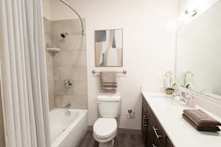 A white bathroom with a toilet, sink, and shower.