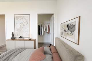 A bedroom with a bed, a dresser, and a wardrobe.