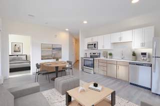 A modern kitchen with a dining table and chairs in the middle of the room.
