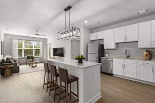 A modern kitchen with white cabinets and a large island.at Forest Edge Apartments, Indiana