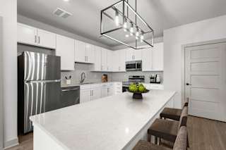 A modern kitchen with a white marble countertop and stainless steel appliances.at Forest Edge Apartments, Charlestown, IN