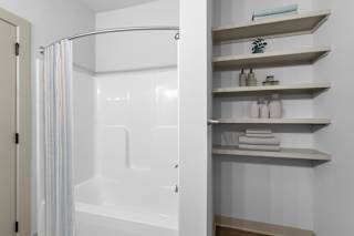 A white bathroom with a shower curtain and a white bathtub.at Forest Edge Apartments, Charlestown