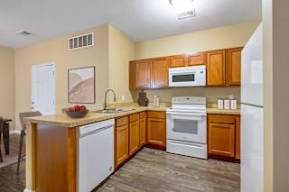 A kitchen with wooden cabinets and white appliances.