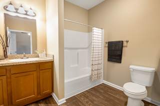 A bathroom with a toilet, sink, and mirror.