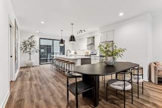 A modern dining room with a large table and chairs.