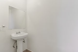 A white sink in a bathroom with a mirror above it.