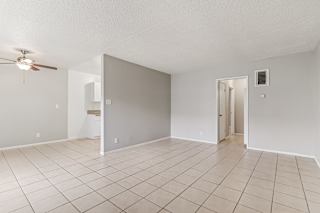 A room with a ceiling fan and tile flooring.