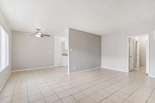 A room with a ceiling fan and tile flooring.