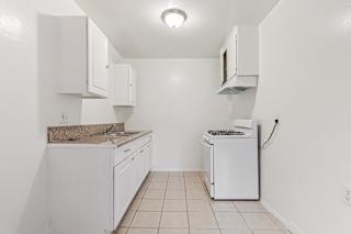 A white kitchen with a washing machine and a microwave.