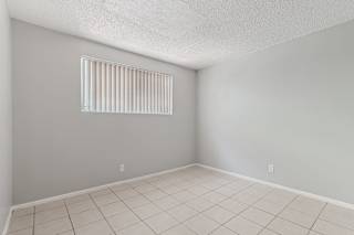 A room with a window and tiled floor.