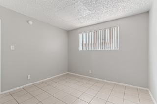 A room with a window covered by white blinds.