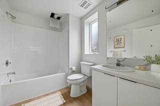 A white bathroom with a toilet, sink, and bathtub.