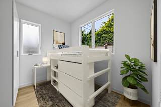 A white bunk bed in a room with a window.