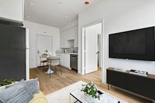 A modern kitchen with a dining table and chairs.