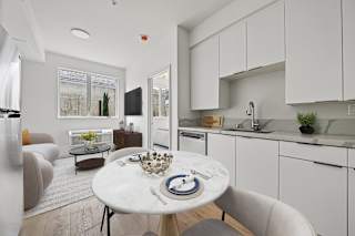 A modern kitchen with a dining table set for two.