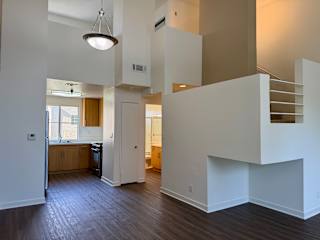 A modern open concept living space with a kitchen, dining area, and stairs.
