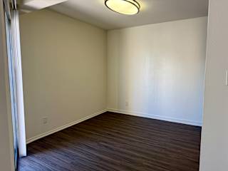 A room with a wooden floor and a white wall.