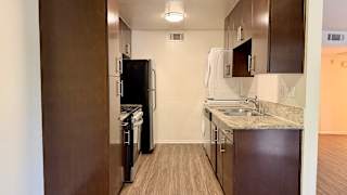 A kitchen with a refrigerator, dishwasher, and sink.