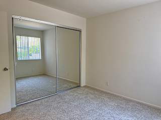 A room with a white door and a carpeted floor.