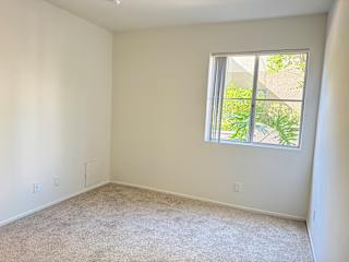 A room with a window and carpeted floor.