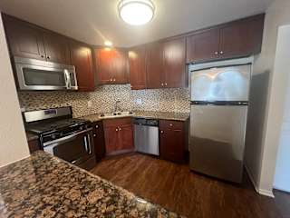 a kitchen with stainless steel appliances and wooden cabinets