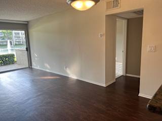 an empty living room with wood floors and a window