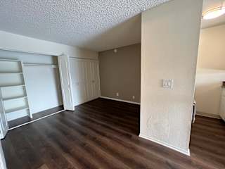 A room with a white door and a brown floor.