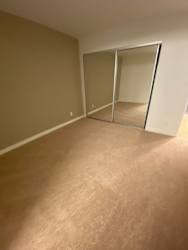 an empty living room with a door to a closet