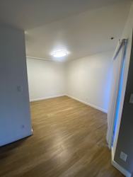 a empty room with white walls and wood floors