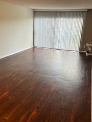 an empty living room with wood floors and a window