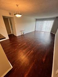 an empty living room with a hard wood floor