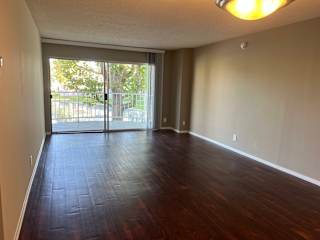 an empty living room with wood floors and a sliding glass door