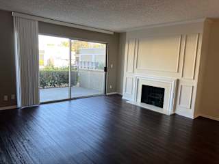 an empty living room with wood floors and a fireplace