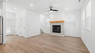A spacious living room with a fireplace and a ceiling fan.at Alante Homes at Spring Run, Caldwell