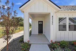 A white house with a black door and windows.