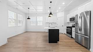 A kitchen with a black island in the middle of it.at Alante Homes at Spring Run, Caldwell, 83607