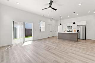 A modern kitchen with a wooden floor and white walls.