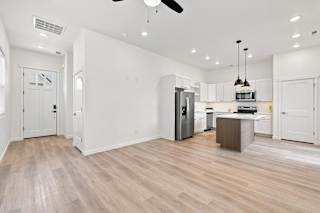 A kitchen with a refrigerator, microwave, and oven.