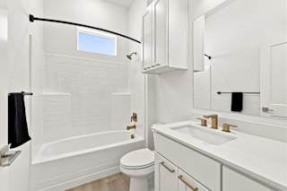 A white bathroom with a toilet, sink, and bathtub.