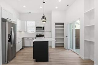 Modern Kitchen with black island and hanging lights at Alante Homes at Spring Run, Caldwell, Idaho