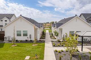 A row of white houses with a playground in the foreground.