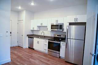 A kitchen with stainless steel appliances and white cabinets.