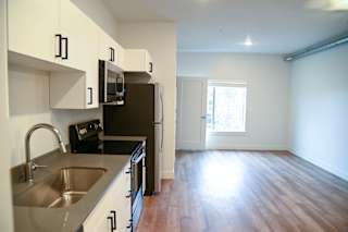 A kitchen with a sink, microwave, and refrigerator.
